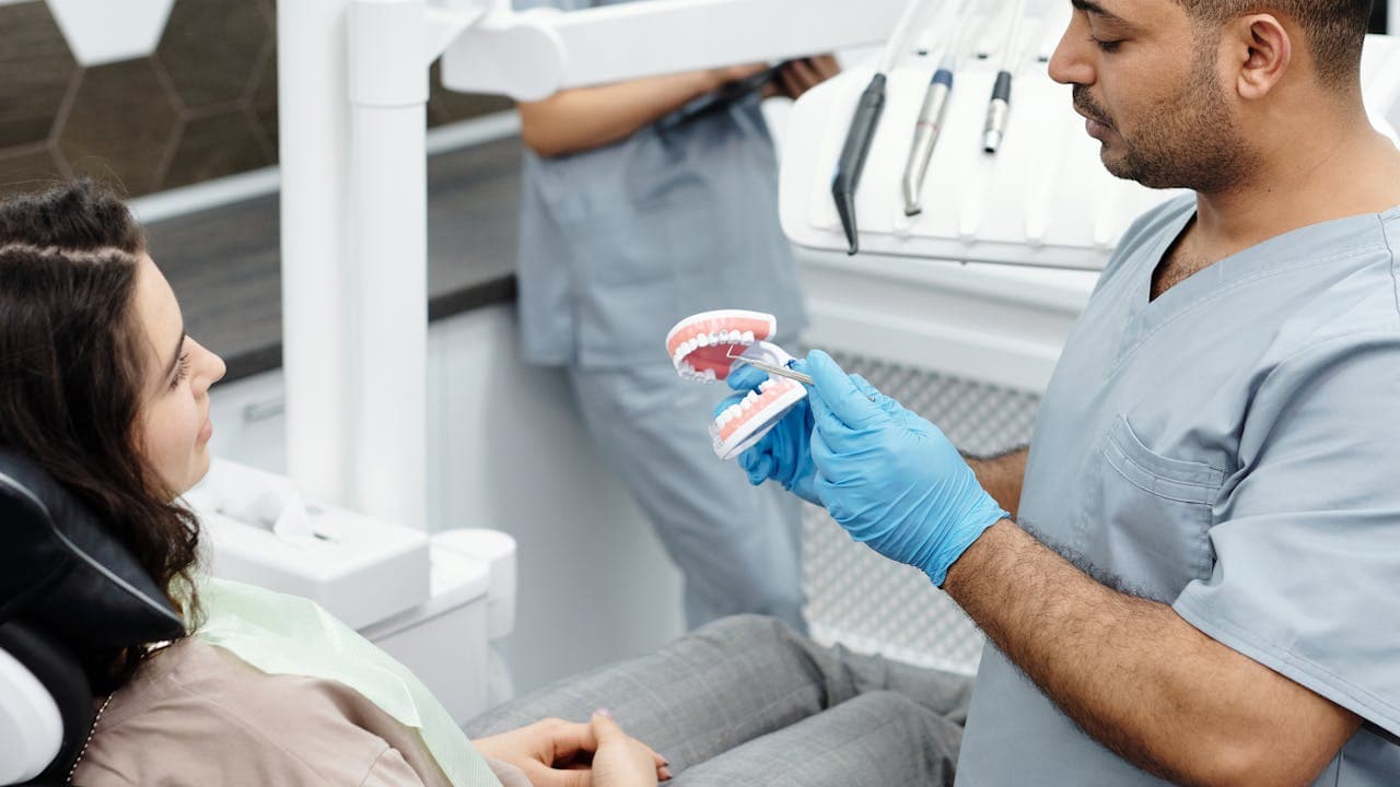 Dentista explicando tratamiento a paciente en consulta moderna