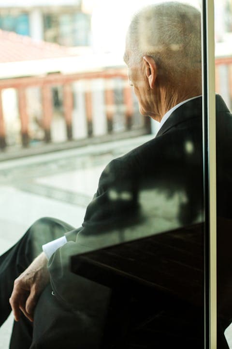 Profesional sentado junto a un ventanal pensando a largo plazo