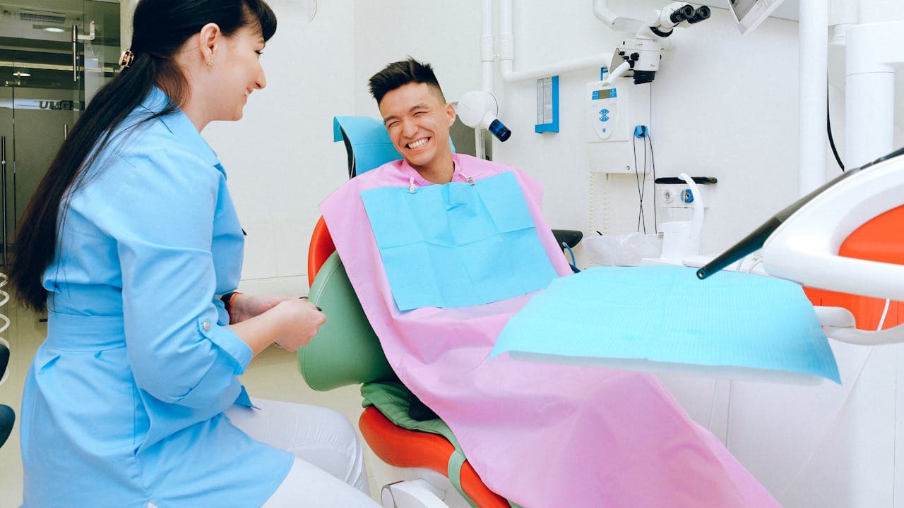 Paciente sonriente en silla dental durante consulta moderna