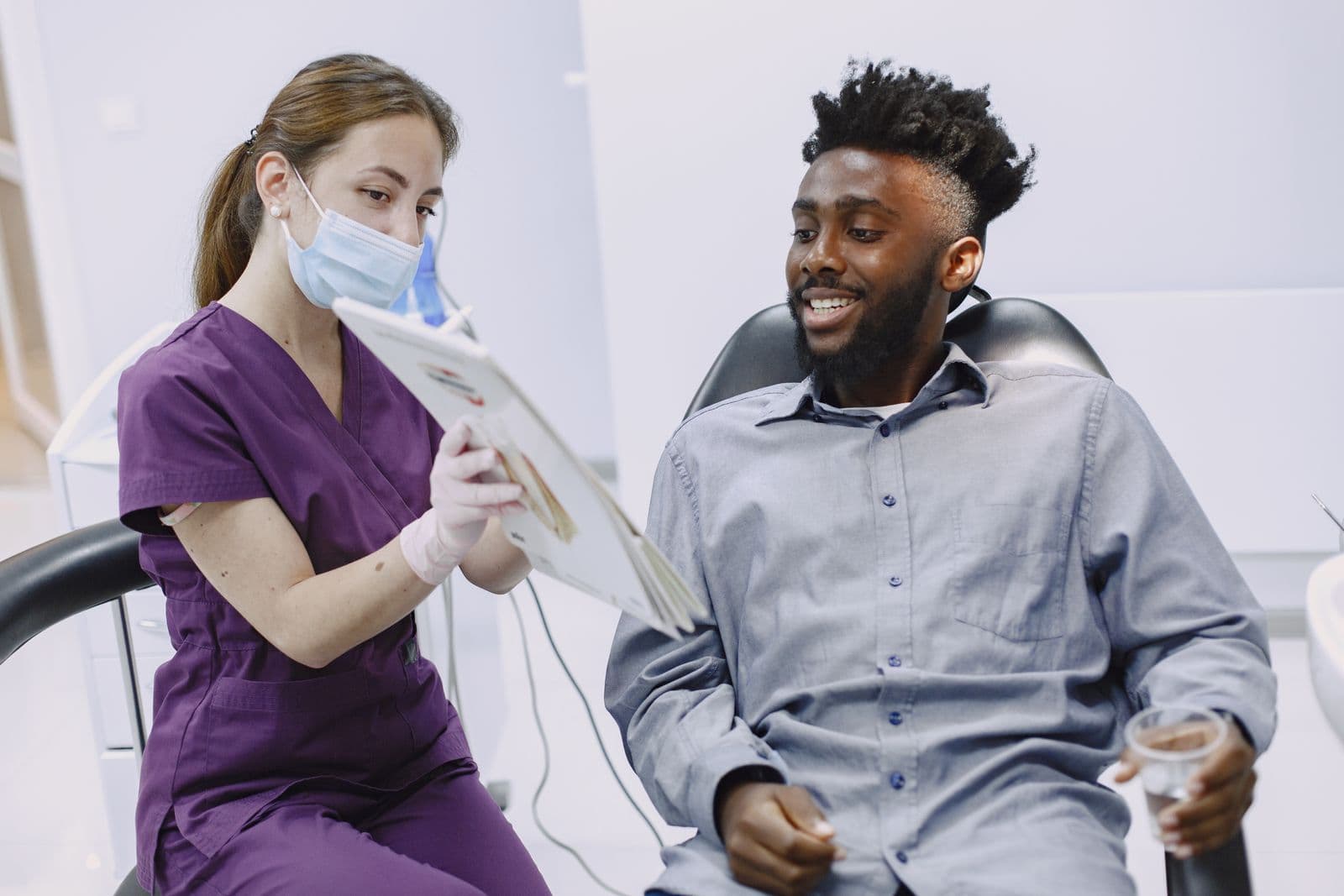 Dentista explicando a un paciente las opciones de su plan de tratamiento en la consulta